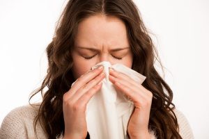 woman sneezing due to poor indoor air quality in her home